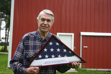 World War II orphan Ferenz "Fritz" Whitman of Riga displays the flag he received when he became a U.S. citizen.